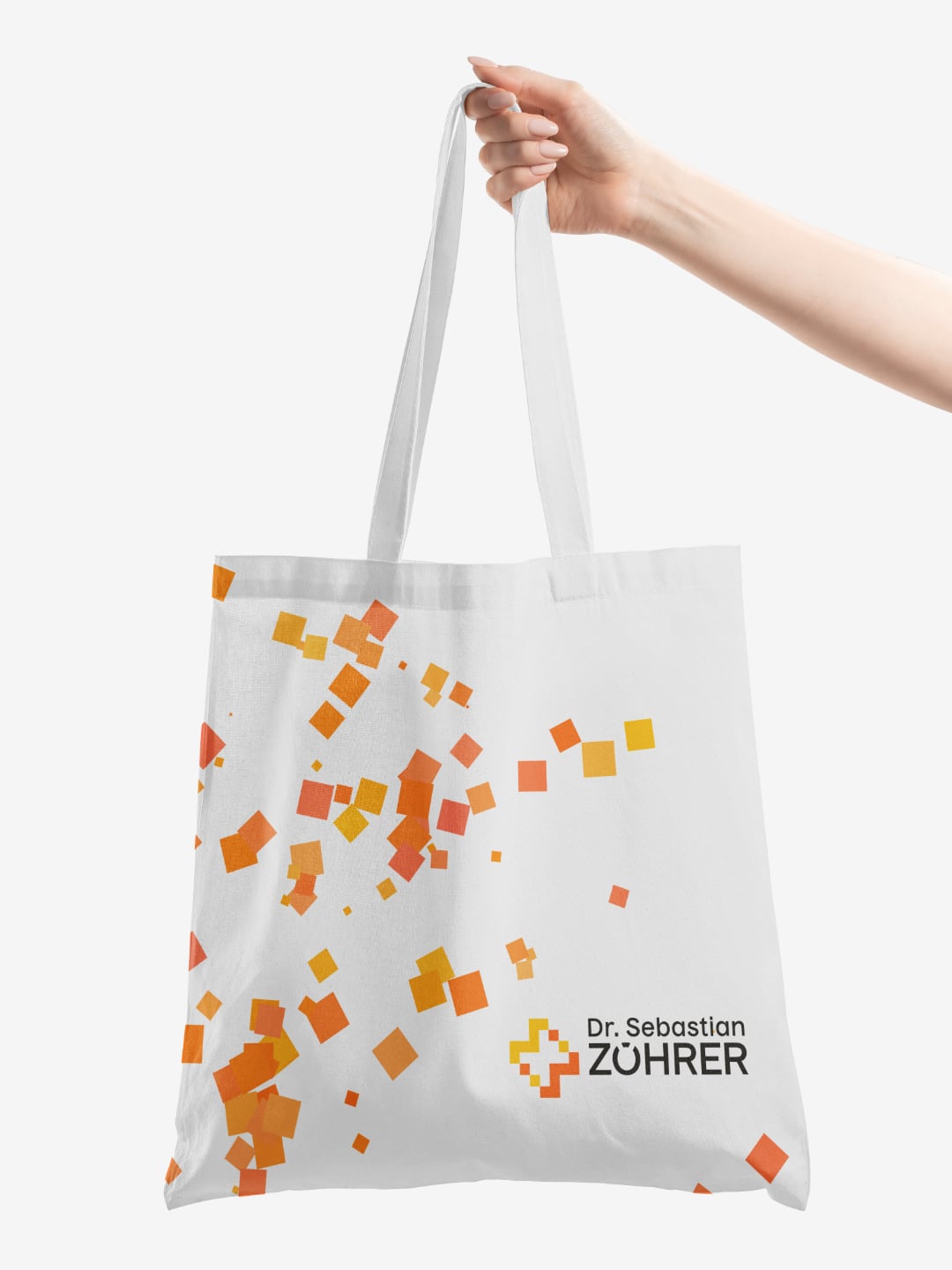 Weiße Tragetasche mit zufällig angeordneten orangefarbenen Quadraten und dem Logo von Dr. Sebastian Zöhrer  | White tote bag with randomly arranged orange squares and the Dr Sebastian Zöhrer logo